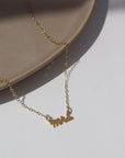 14k gold fill Mrs.Necklace laid on a white jewelry dish in the sunlight. This is perfect to gift any bride to be in your life.