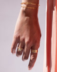 Model found wearing 14k gold fill Trinity Ring, worn with multiple other rings.