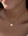 model found wearing 14k gold fill monogram toggle necklace. This necklace features the narrow link chain connected by a toggle with the monogram disc.