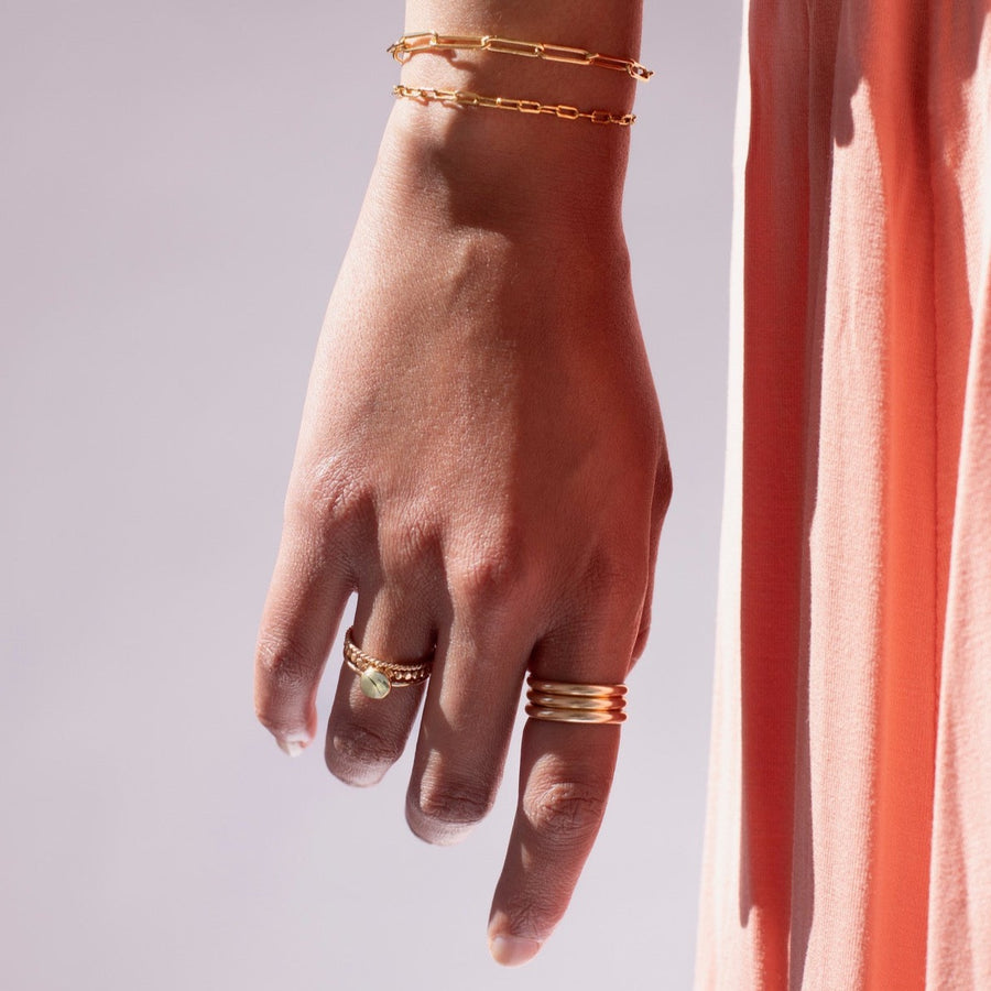 Model found wearing 14k gold fill Trinity Ring, worn with multiple other rings.