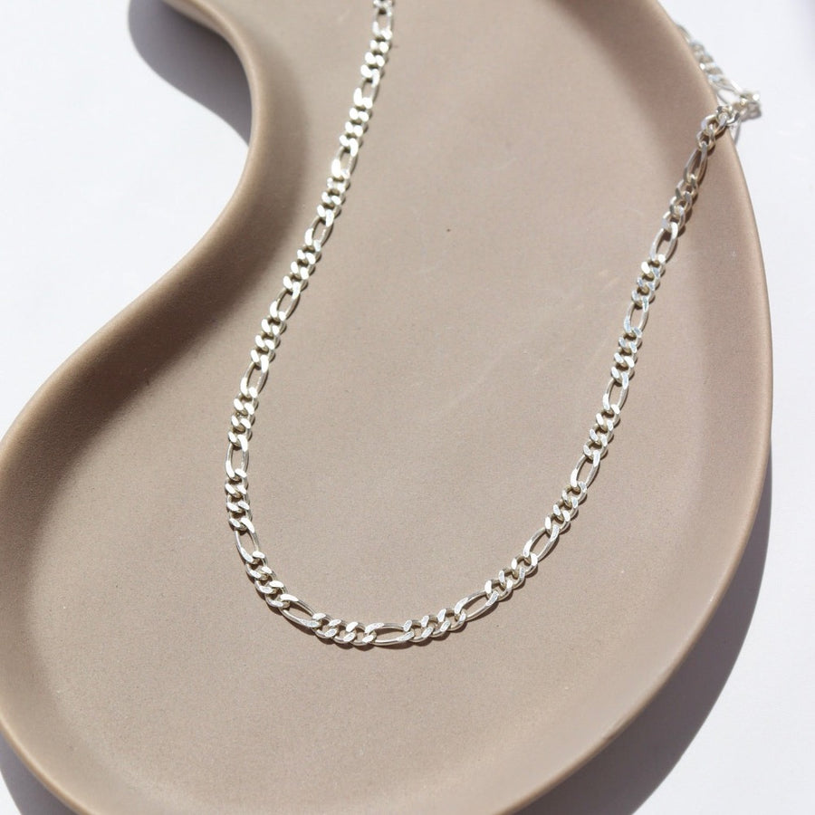 925 Sterling silver Gigi Necklace laid on a white plate in the sunlight.