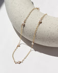 dainty pearls on a 14k gold filled chain photographed on a ceramic dish