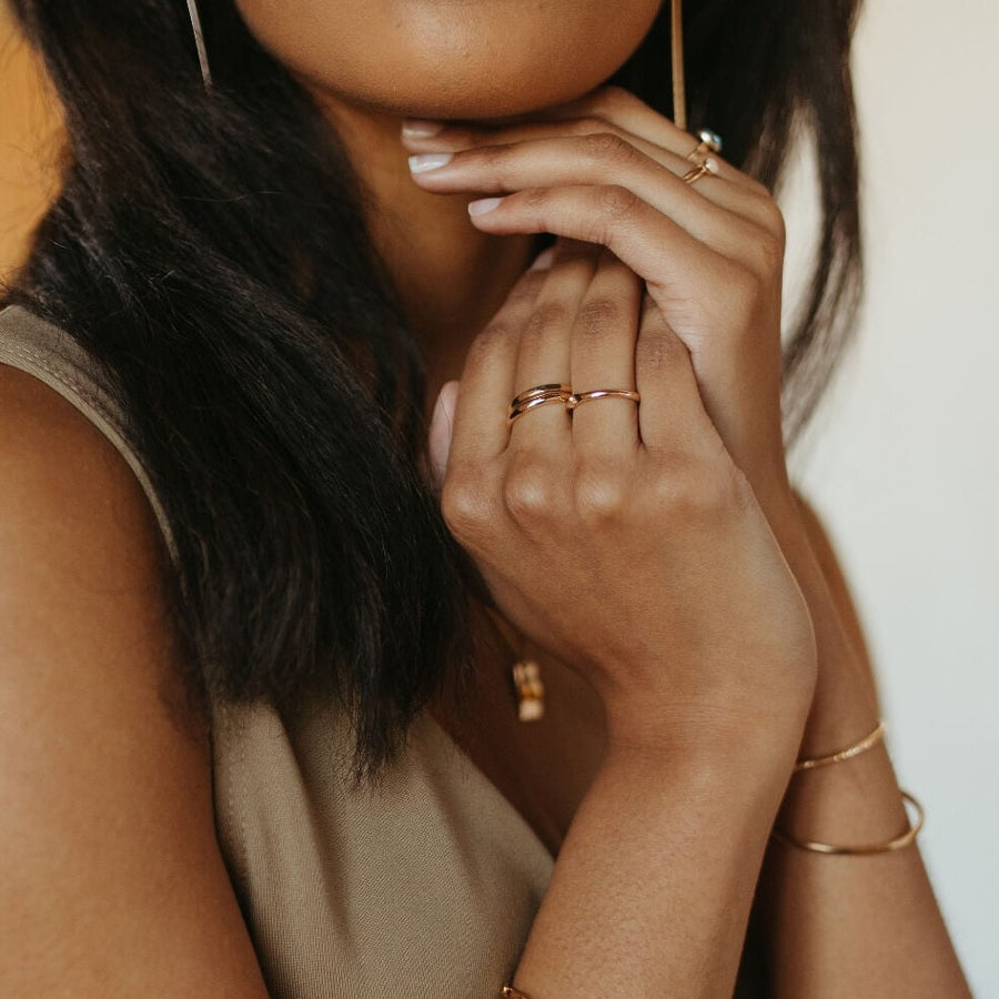 model is wearing a 14k gold fill Heritage band. The heritage band Features a lightly hammered band to a high shine.