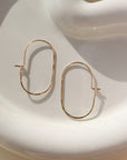 14k gold fill capsule hoops laid on a white plate. Handmade in Eau Claire, Wisconsin.