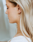 Model wearing 14k gold fill Petite Pearl Hoops, These earrings feature a Goldie hoop with three tiny gemstone studs. - Token Jewelry