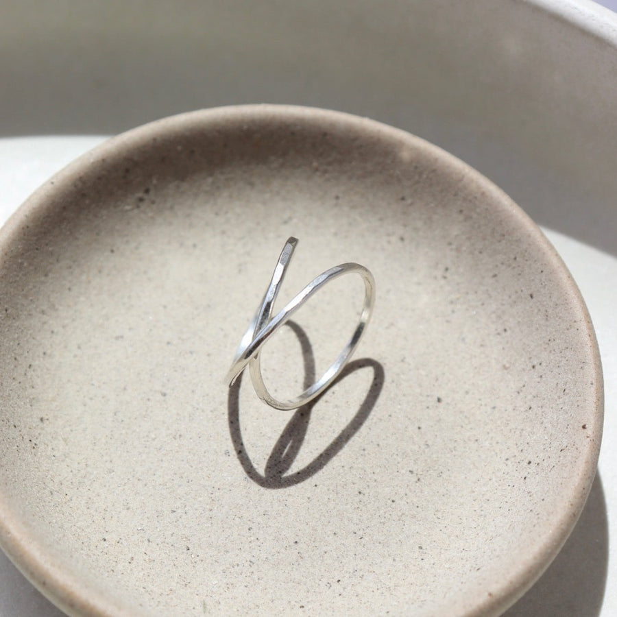 925 Sterling silver infinity Ring laid on a tan plate. This Ring features the symbolism of the infinity meaning forever. Also makes it look like you are wearing two rings on the one finger. Super cute statement ring.