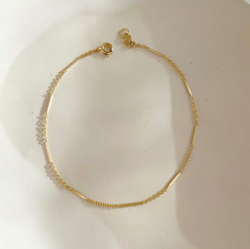 14k gold fill Sailor Bracelet set on a white plate in the sunlight. - Token Jewelry
