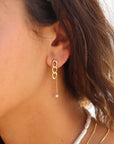 Model wearing 14k gold fill chain link drop earrings with a delicate chain and freshwater pearl accent, styled with layered gold necklaces and a freshwater pearl necklace.