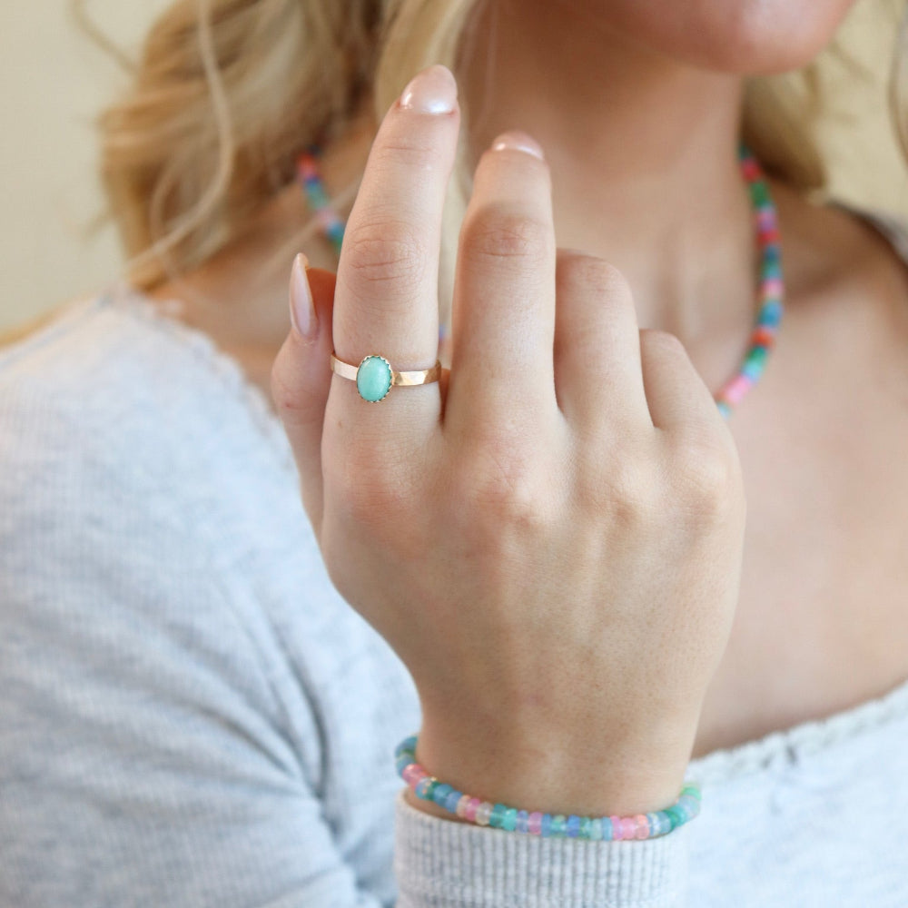 Model wearing the azura amazonite ring. This ring features a 6x8mm amazonite gemstone set in a 14k gold fill serrated bezel.