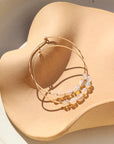 14k gold fill hoop earrings with opals wire wrapped on a light dish