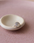 14k gold fill mother of pearl ring placed on a white plate in the sunlight.