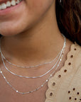 sterling silver delaney necklace layered between two other sterling silver necklaces