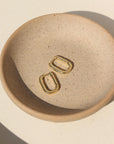 14k gold filled small rectangular huggie hoop earring with clasp closure on a jewelry dish
