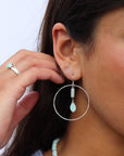 Model wearing a sterling silver hoop with druzy + burma jade gemstones dropping from the ear post.