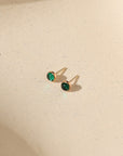 14k gold fill bezel studs with 4mm emerald stones on a light background