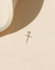 sterling silver handmade hammered cross charm on a light background