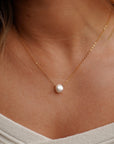 model wearing 14k gold fill delicate chain with freshwater pearl