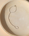 sterling silver hand chain with pearls on a light dish