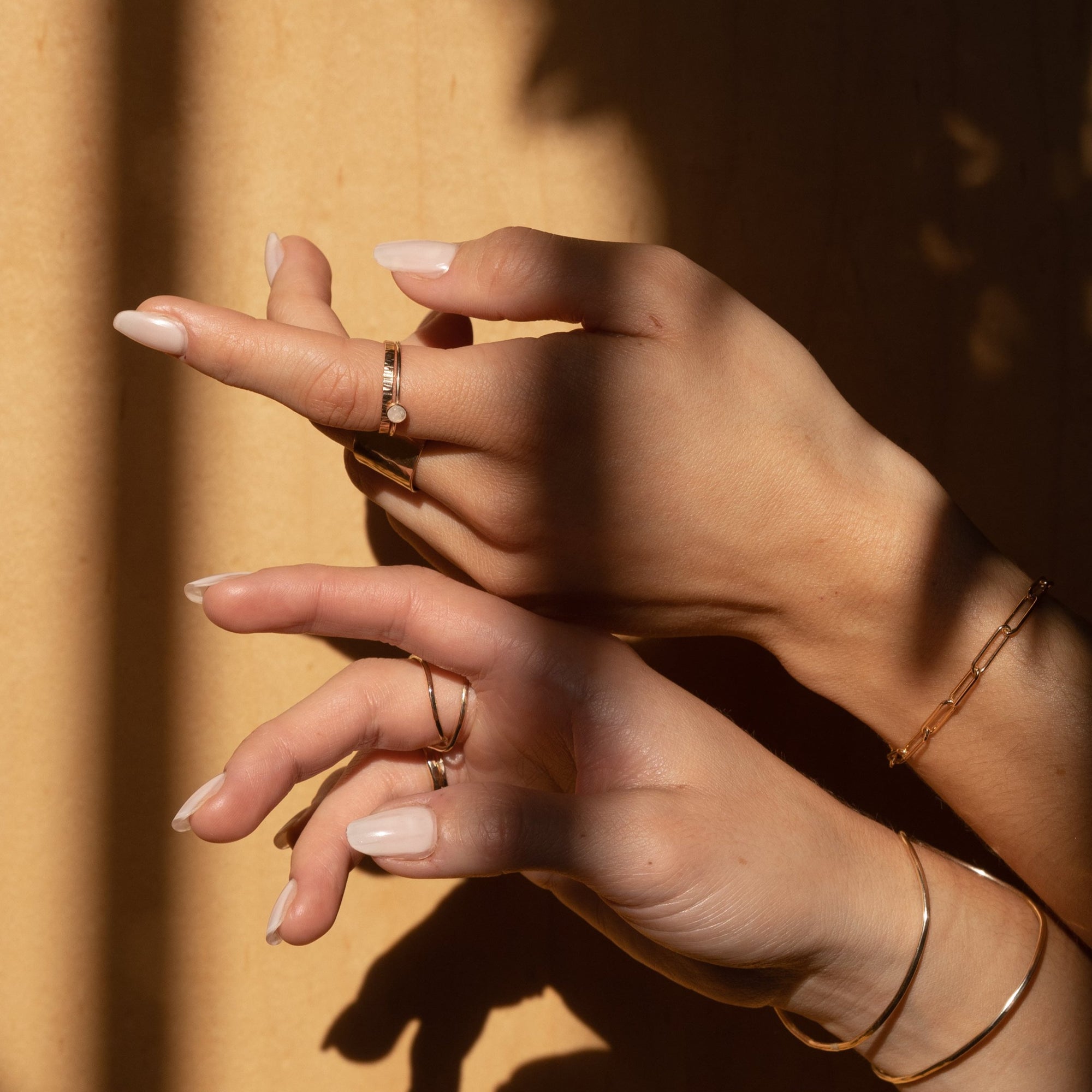 Hands with 4mm moonstone ring on in the shadows.