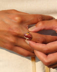 The Harvest Ring features a mookite gemstone encased in a pretty oval bezel, set within your choice of a textured 14k gold fill or sterling silver band.