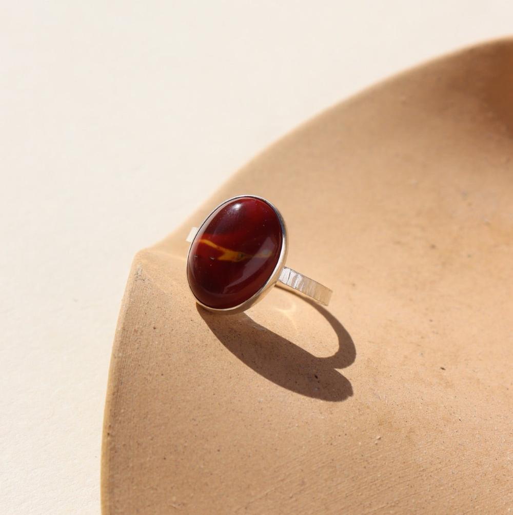 The Harvest Ring features a mookite gemstone encased in a pretty oval bezel, set within your choice of a textured 14k gold fill or sterling silver band.