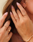 Close-up of hands with gold jewelry on a neutral background