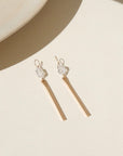 14k gold fill drop hoop charms with a herkimer gemstone wire wrapped to a gold drop post. The earrings are displayed on a cream backdrop in the sunlight