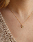 model wearing 14k gold fill disk with horseshoe stamp on a delicate chain necklace