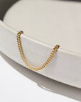 14k gold fill La Mer Anklet laid on a white plate in the sunlight.