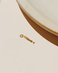 Small gold sardine fish charm with detailed texture and polished finish.
