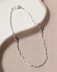 925 Sterling silver Narrow Link Anklet laid on a tan plate  