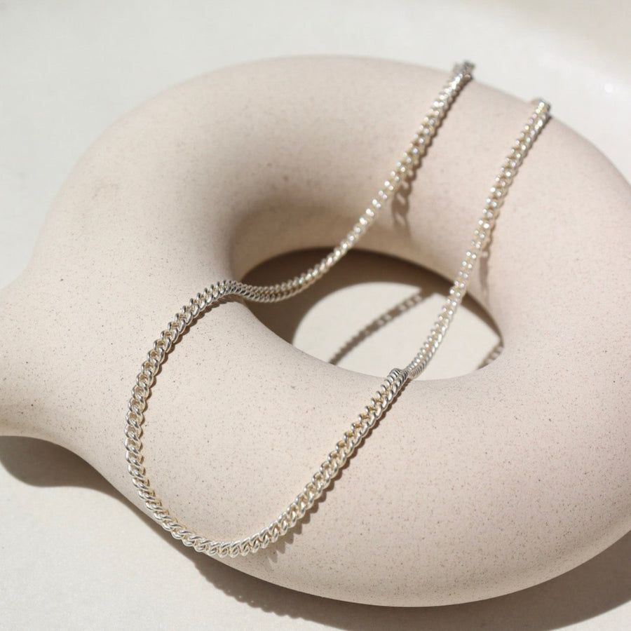 925 Sterling silver La mer Anklet laid on a white pot on a white plate in the sunlight.