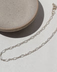 925 Sterling silver Clara Anklet laid on a white plate in the sunlight.