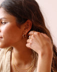 Model wearing 14k gold fill Classic hoops in the classic size as well as the mini size.