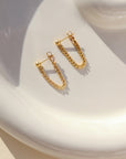 14k gold fill small curb chain stud earrings on a light dish