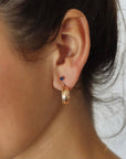model wearing 14k gold fill hammered textured stud hoop earrings with stud gemstone earrings