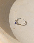 sterling silver bezel ring with 4mm lapis lazuli gemstone on a light dish