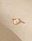 14k gold fill heart charm with jump ring stamped with an 'H' on a light background in the sunlight