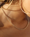 model wearing 14k gold fill chain necklace in the sunlight
