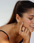 Brunette model wearing the laine ring. This ring features a gold hammered band with rippled edges.