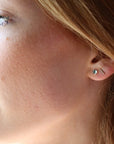 4mm Blue Topaz gemstones set in a 14k gold fill bezel stud earring and placed on a white plate for display. Sold as a pair and perfect for single or double pierced ears. Handmade by Token Jewelry in Eau Claire, WI. Blue Topaz is the birthstone for December.