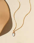 A 14k gold fill box chain featuring a Marquise Moonstone Gemstone wired wrapped at the end. Necklace is displayed on a cream back drop.