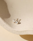 sterling silver bezel ear post with 4mm moonstones on a light dish