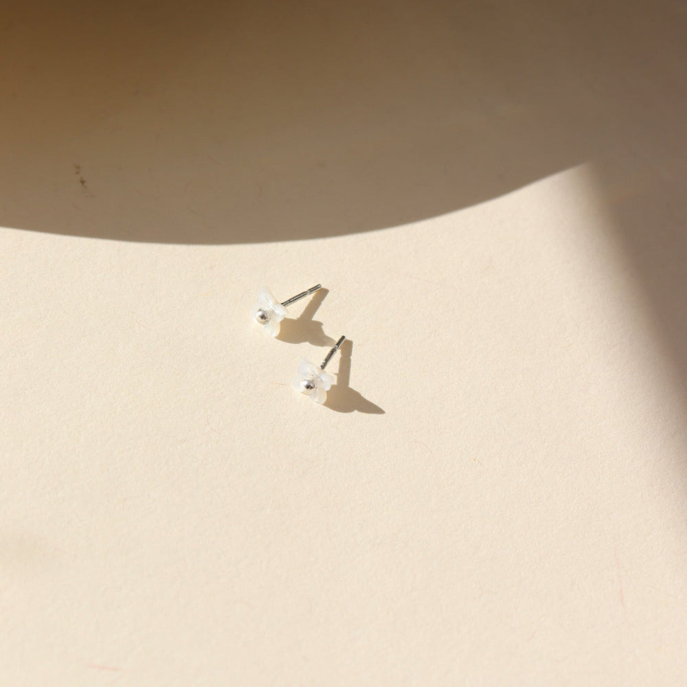 A sterling silver classic ball post stud with mother of pearl petals surrounding the stud.