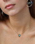 Model wearing spear-shaped labradorite pendant on gold chain, handmade anniversary jewelry