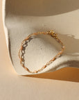 14k gold fill chain alternating with transparent opal gemstones as a bracelet in the sunlight