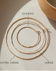 14k gold fill hoop earrings on display showing the different sizes on a light table