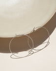 sterling silver hammered hoop earrings on a light dish