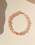 This bracelet features 29 pink pearls with a small gold bead inbetween each three pearls. This bracelet includes a gold clasp and extender.