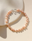 This bracelet features 29 pink pearls with a small silver bead inbetween each three pearls. This bracelet includes a silver clasp and extender.